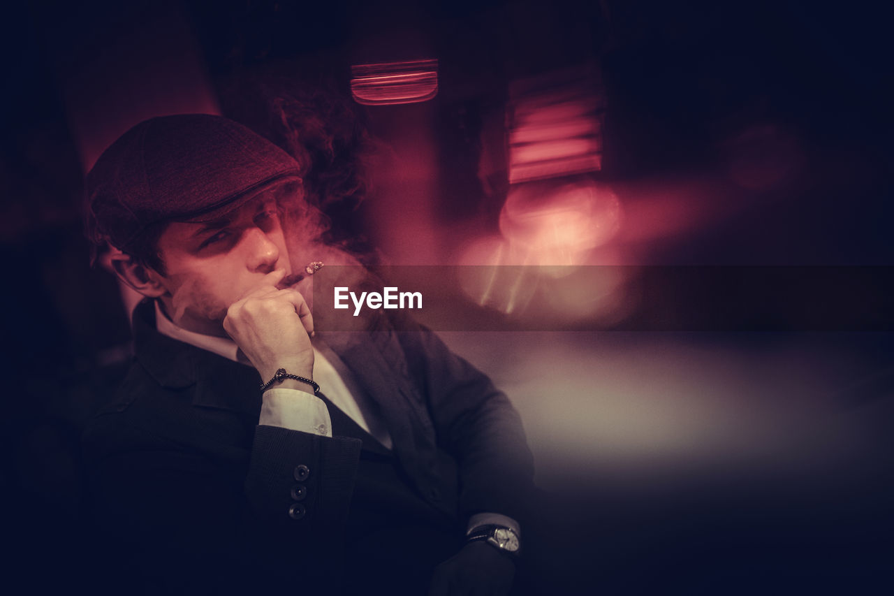 Young man smoking at night