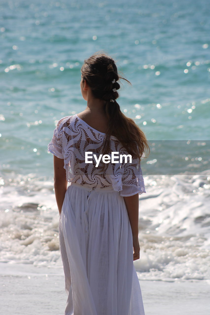 Rear view of woman standing on beach