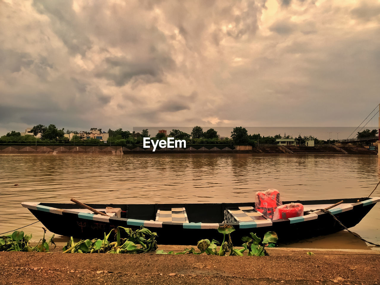 BOATS MOORED BY LAKE AGAINST SKY