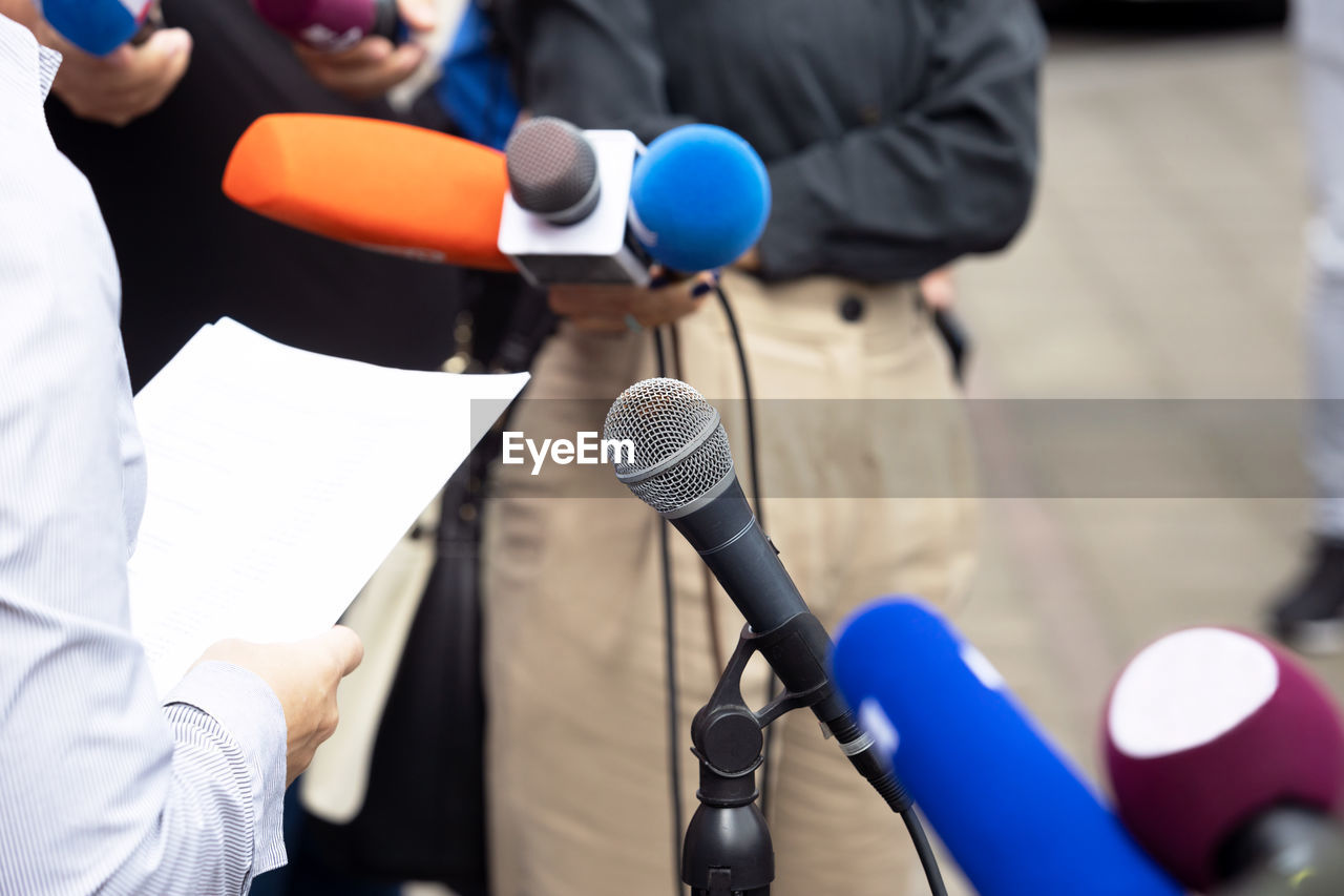 Whistleblower holding documents and giving statement at media event or news conference