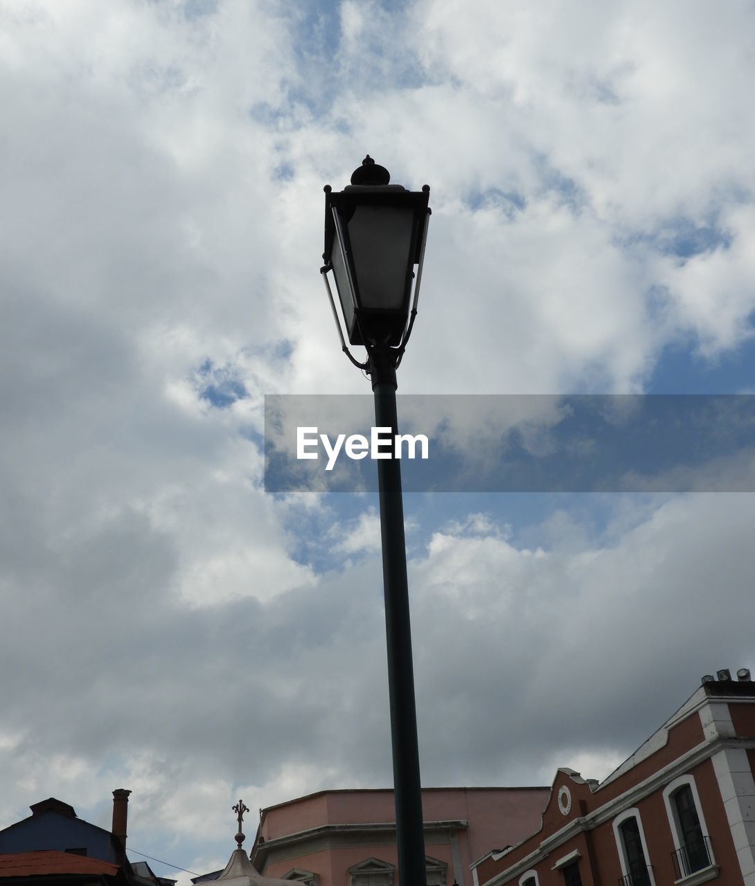 LOW ANGLE VIEW OF STREET LIGHTS AGAINST CLOUDY SKY