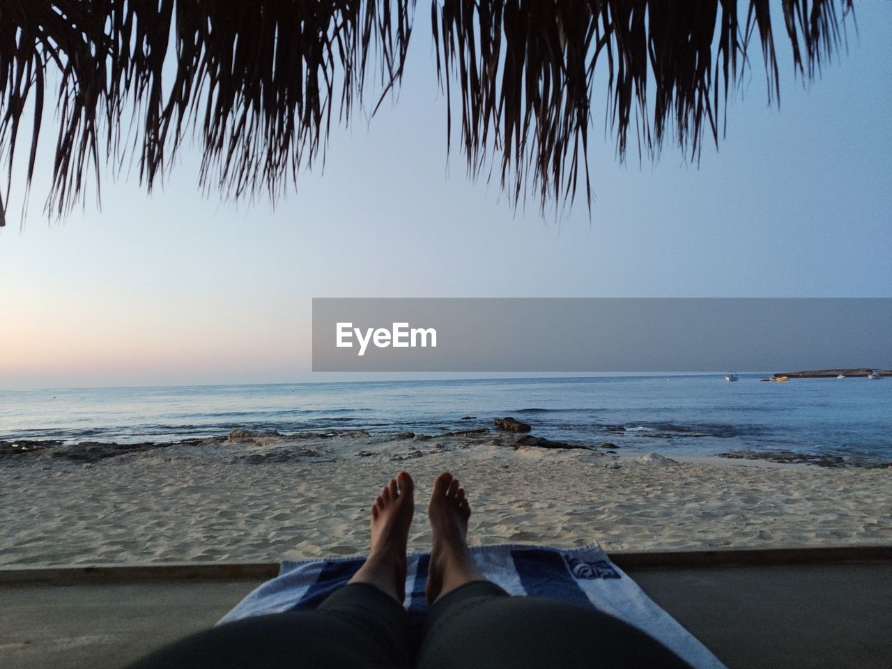 Low section of woman relaxing at beach