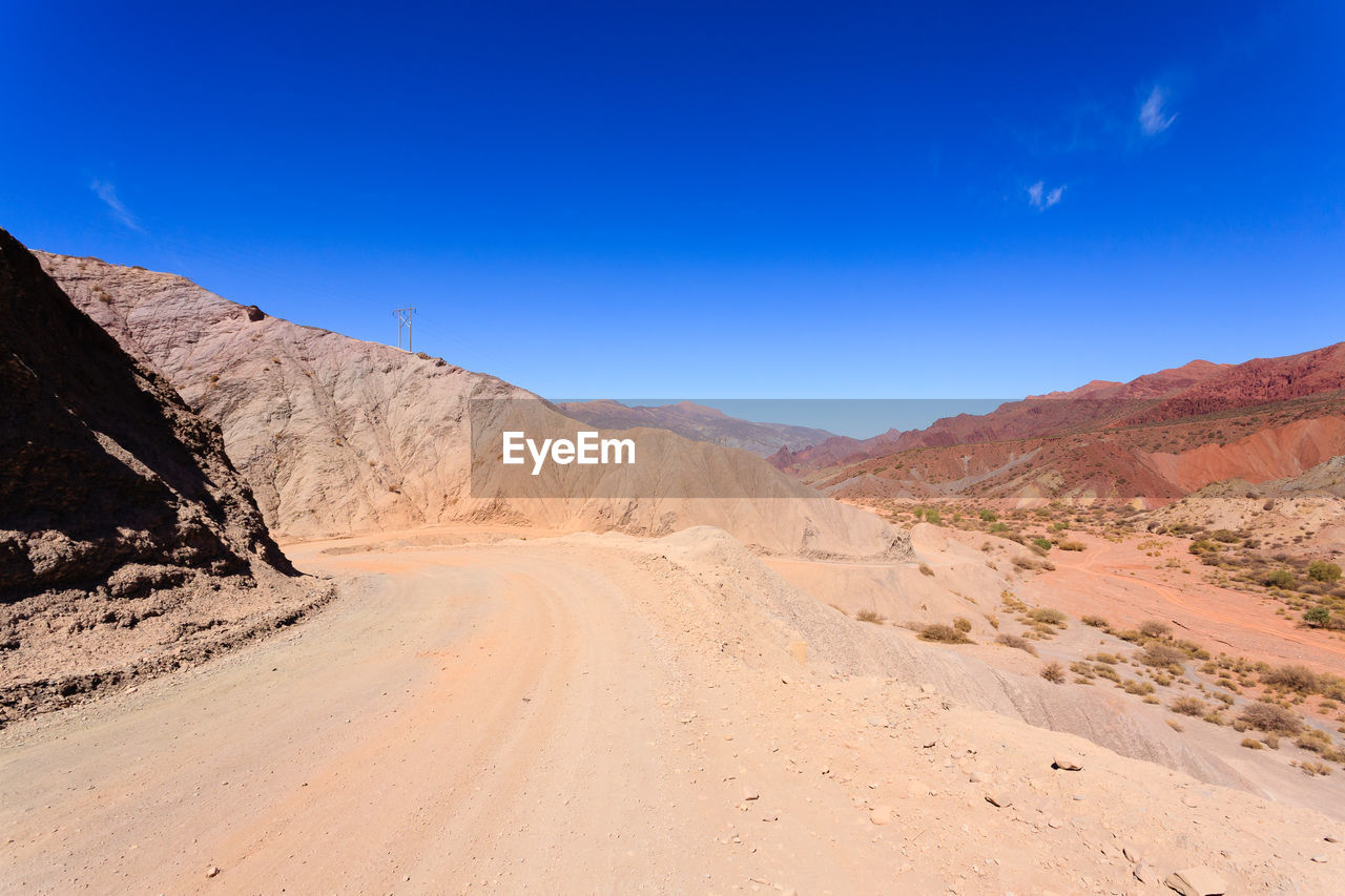 SCENIC VIEW OF ROAD AGAINST CLEAR BLUE SKY