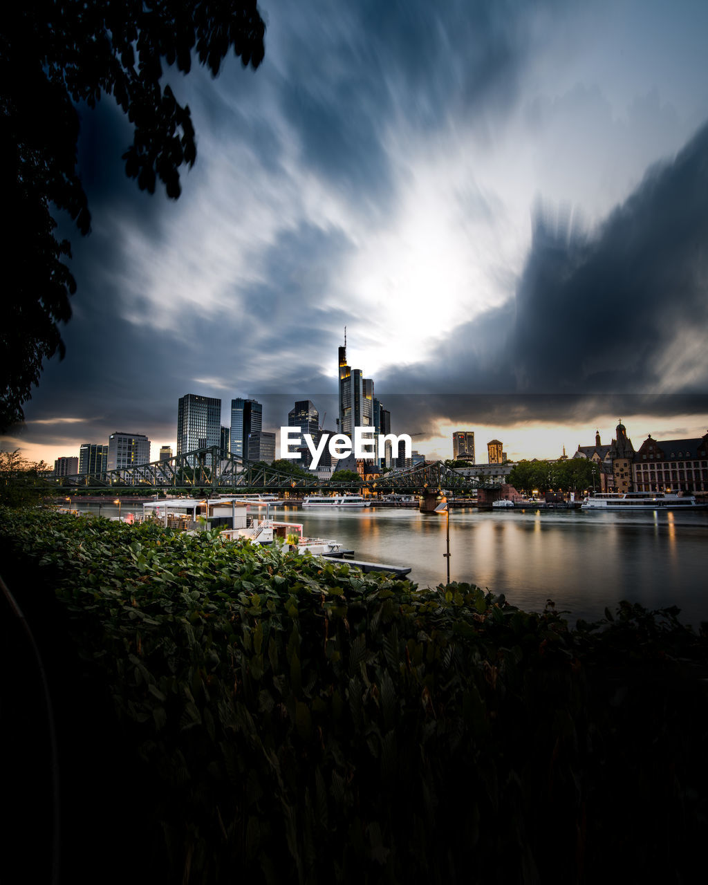 River by illuminated city against sky at dusk in frankfurt, germany 