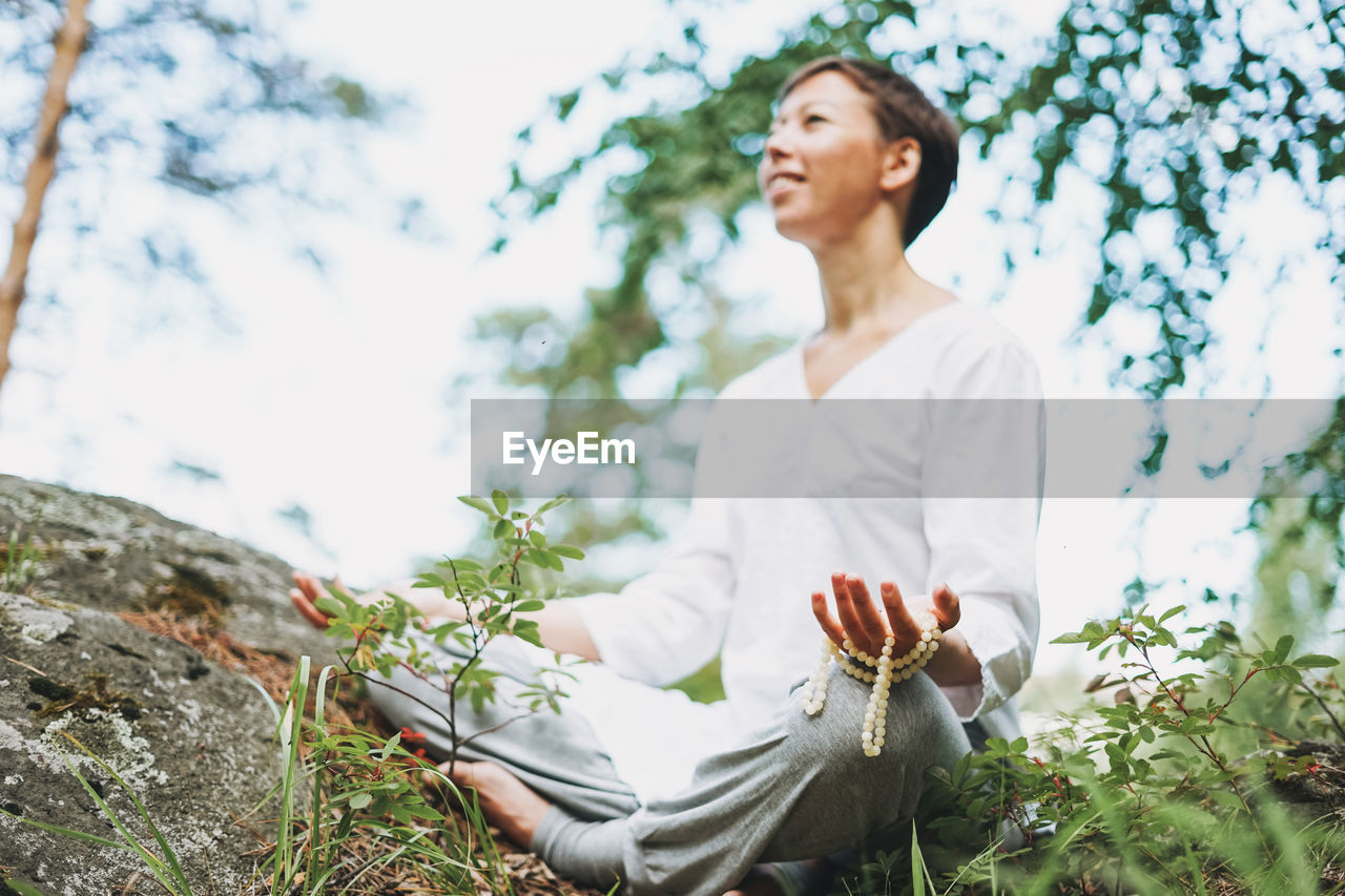 Young smiling woman practice yoga outdoors. new normal social distance. physical and mental health