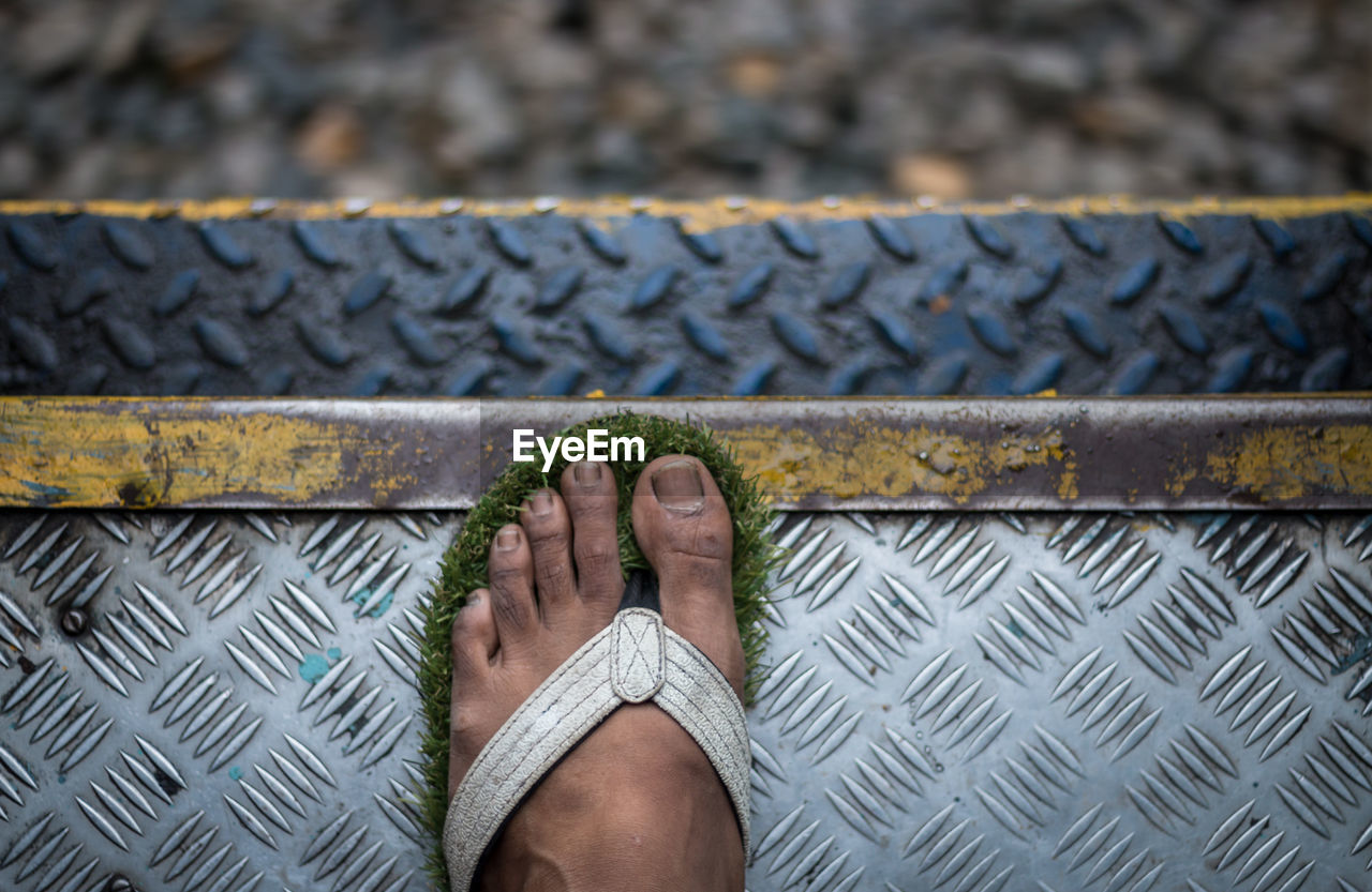 Low section of person standing on train