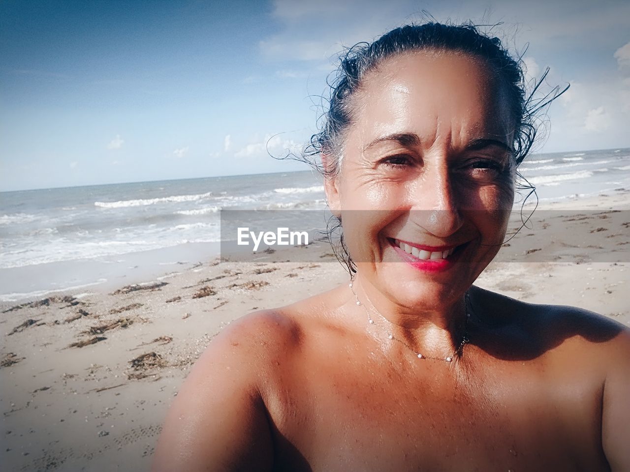 PORTRAIT OF SMILING MAN ON BEACH