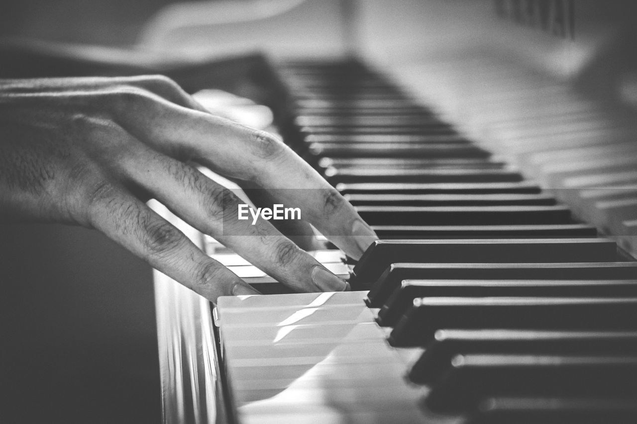CLOSE-UP OF HANDS PLAYING PIANO AT HOME