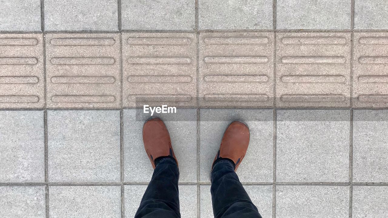 Low section of man standing on footpath