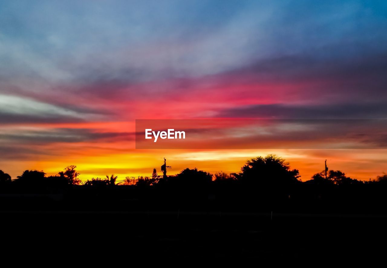 SCENIC VIEW OF SILHOUETTE FIELD AGAINST ORANGE SKY