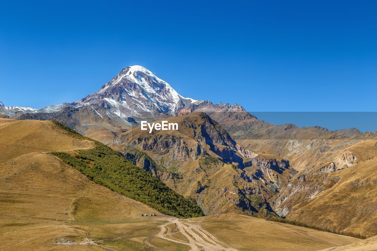 Scenic view of mountains against clear blue sky