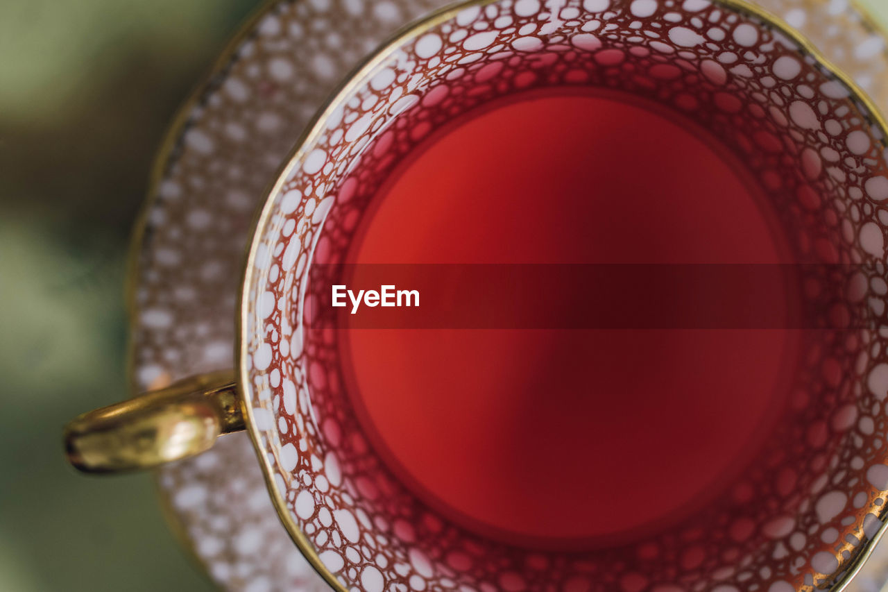 Directly above shot of hibiscus tea in pink and gold teacup