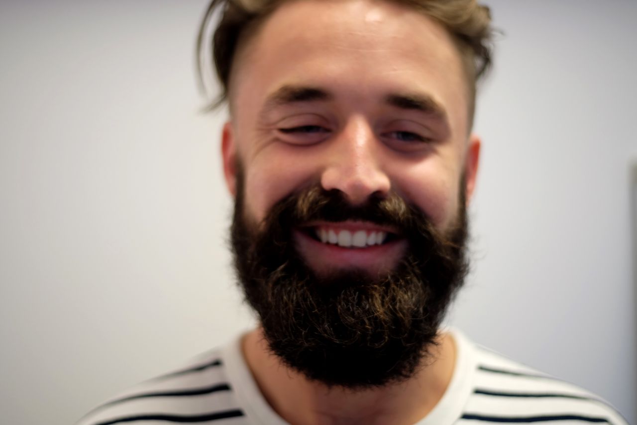 Close-up of happy young man against wall