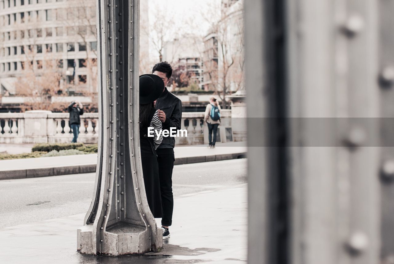 Couple standing by column