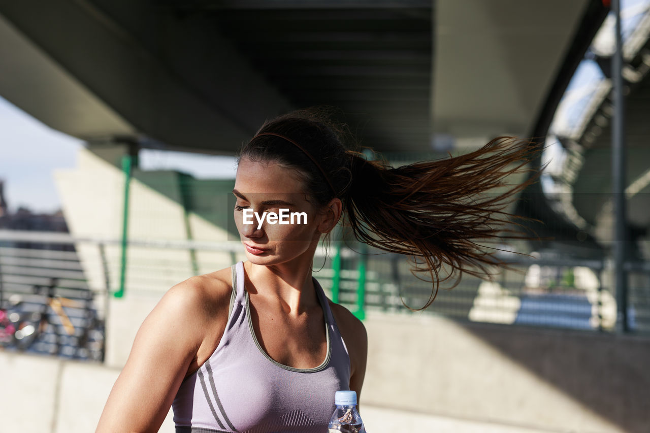 Close-up of young woman tossing hair