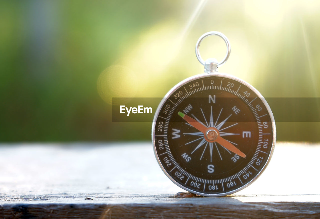 Close-up of information sign compass on table