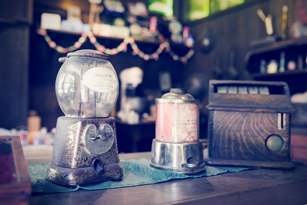 Close-up of old candy dispensing machines on table in restaurant
