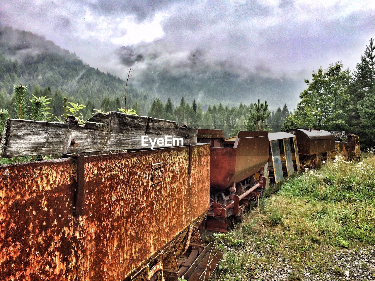 Abandoned freight train against cloudy sky
