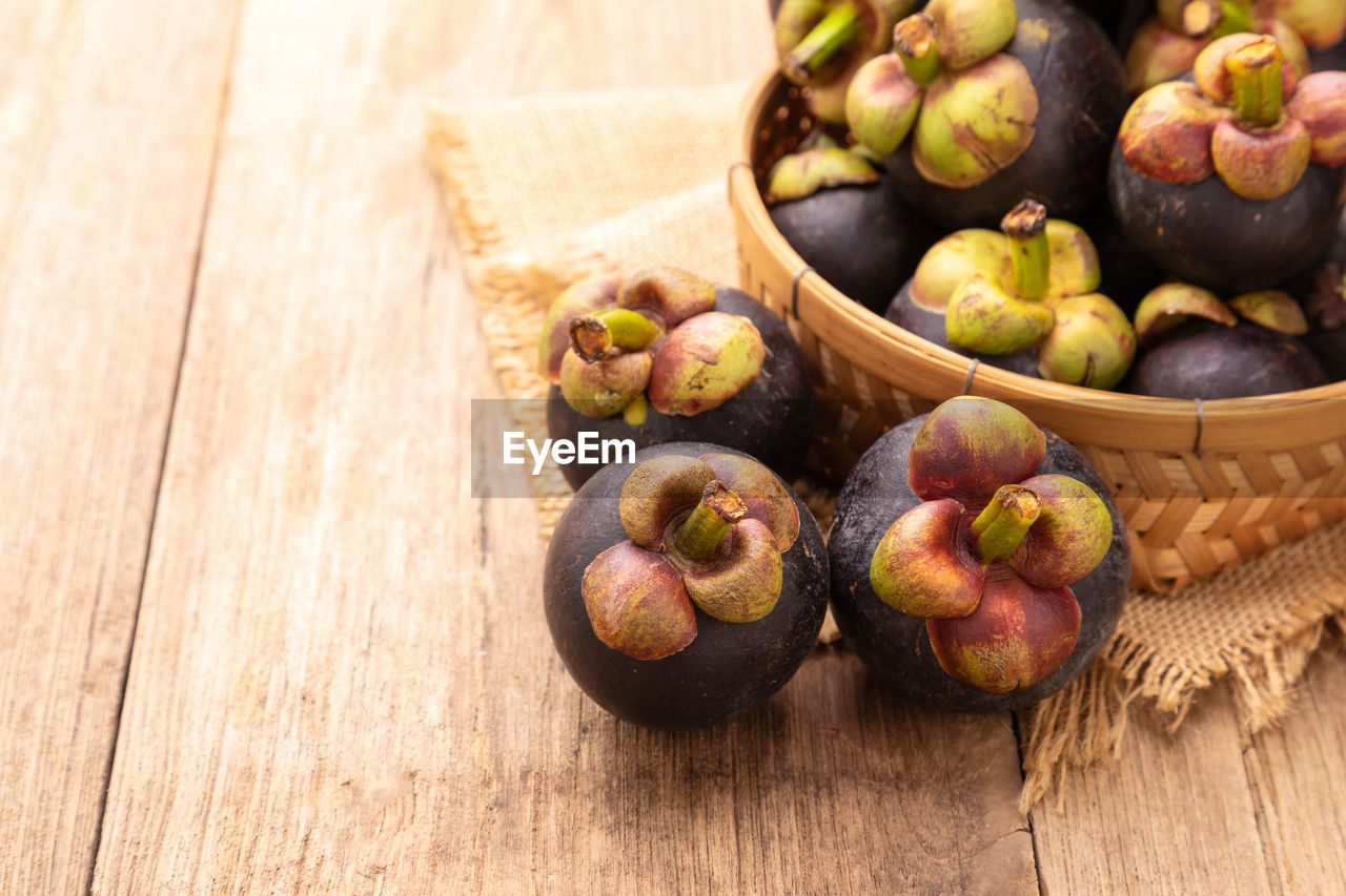 Close up pile of mangosteen on wooden table background. food and healthcare concept