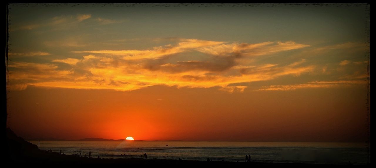 Panoramic view of beach against orange sky during sunset