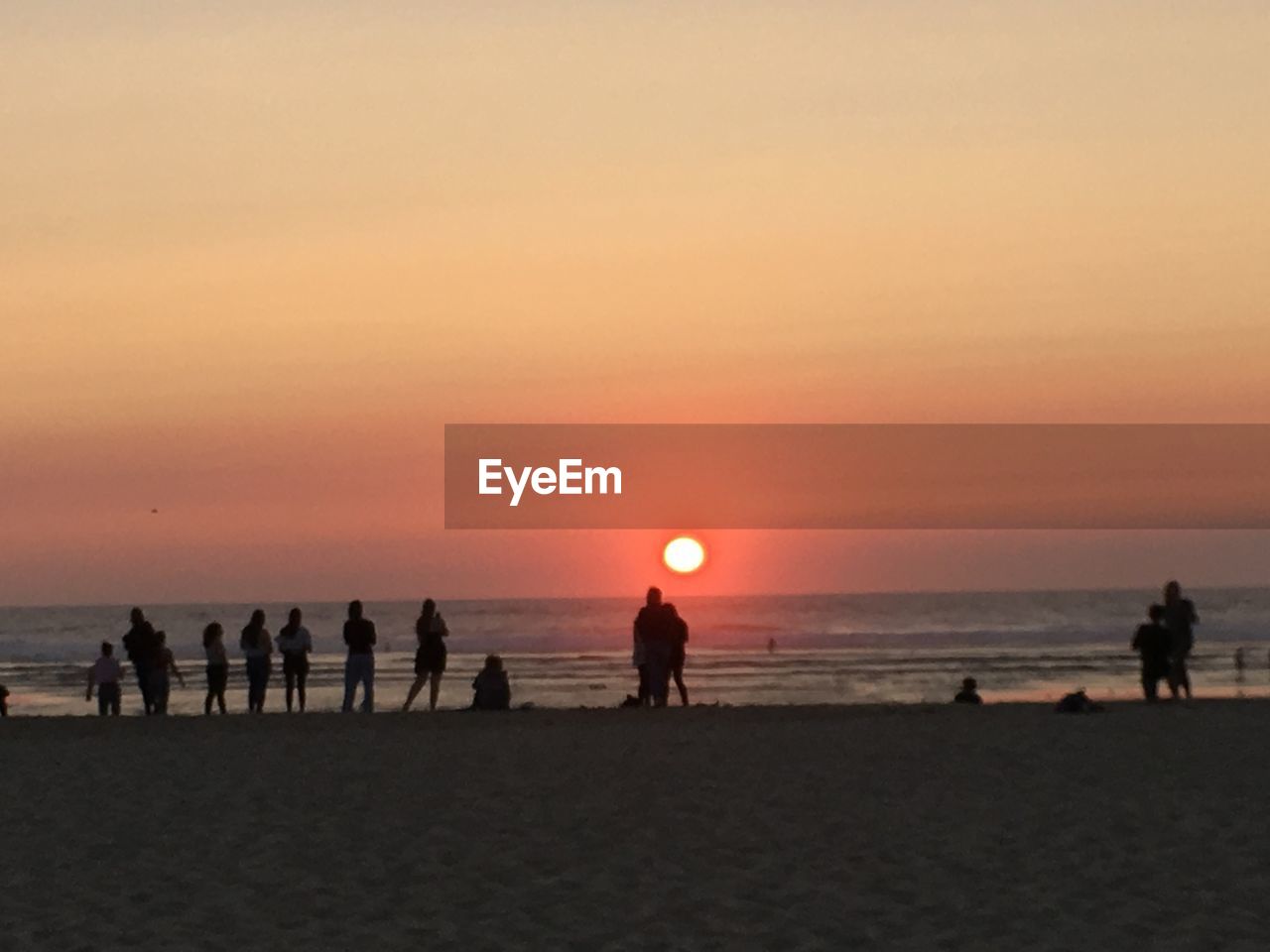 SILHOUETTE PEOPLE ON BEACH AGAINST SKY AT SUNSET