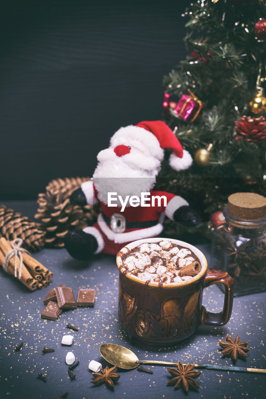 Coffee cup and santa claus toy on table