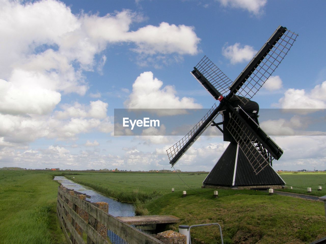 Traditional windmill on field against sky