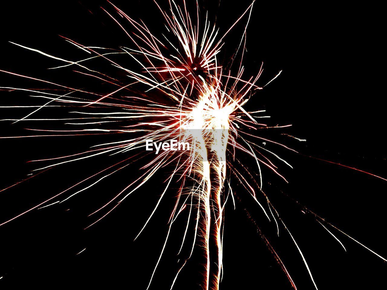 LOW ANGLE VIEW OF FIREWORKS EXPLODING AT NIGHT