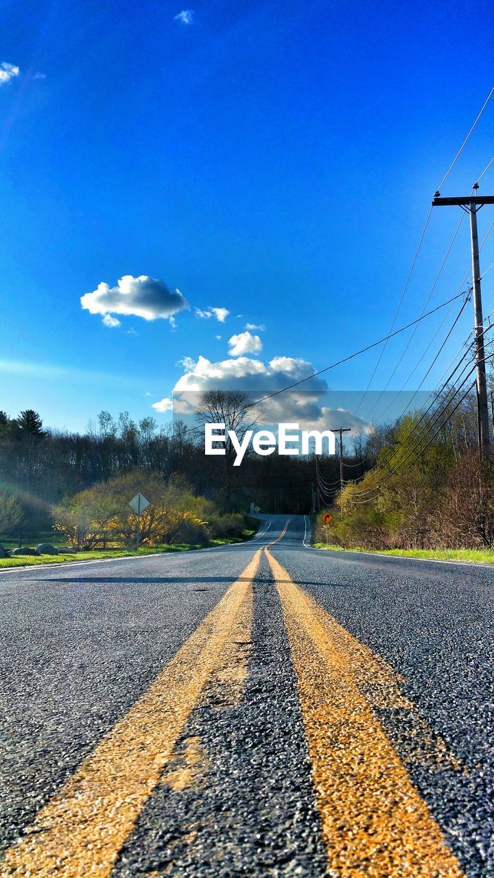 ROAD BY RAILROAD TRACK AGAINST SKY