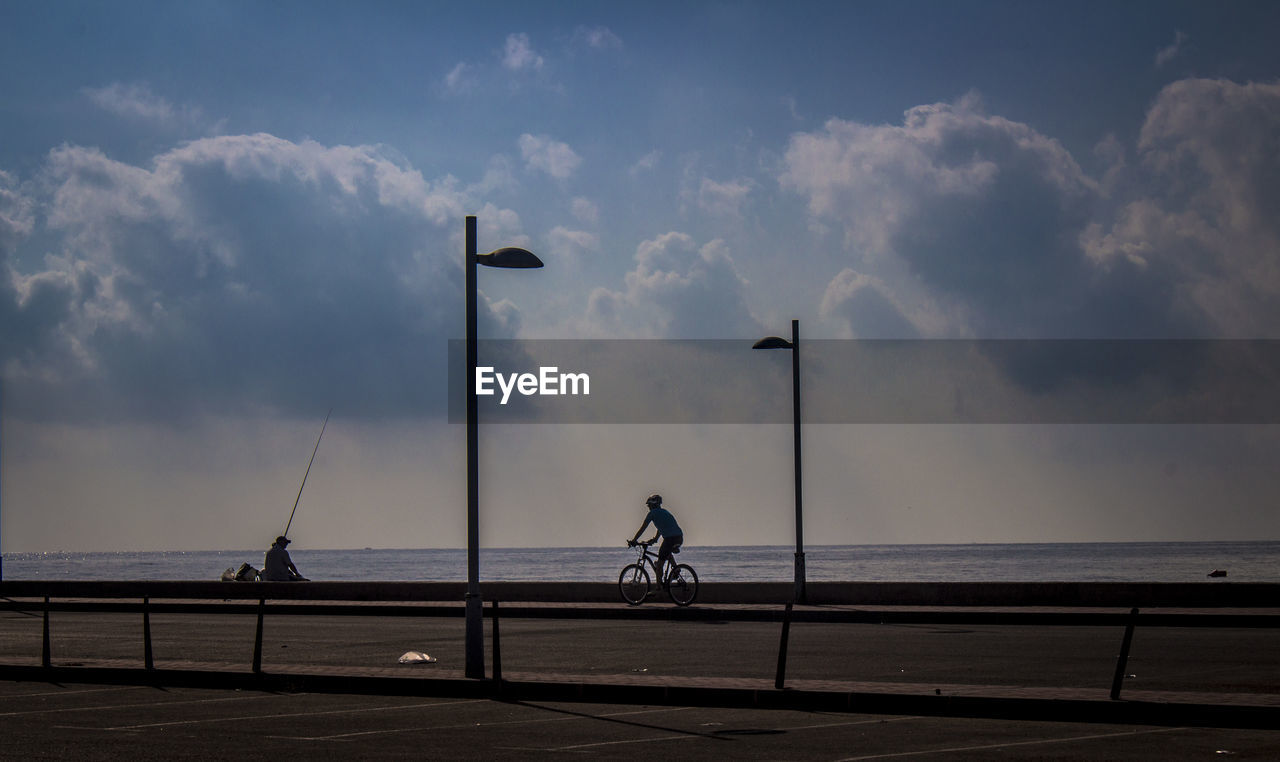 PEOPLE RIDING BICYCLE ON ROAD