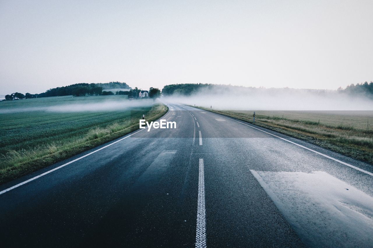 Empty road along countryside landscape