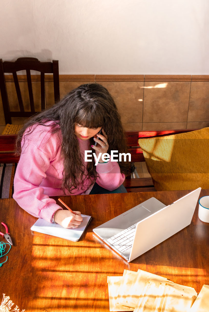 high angle view of woman sitting on table at home