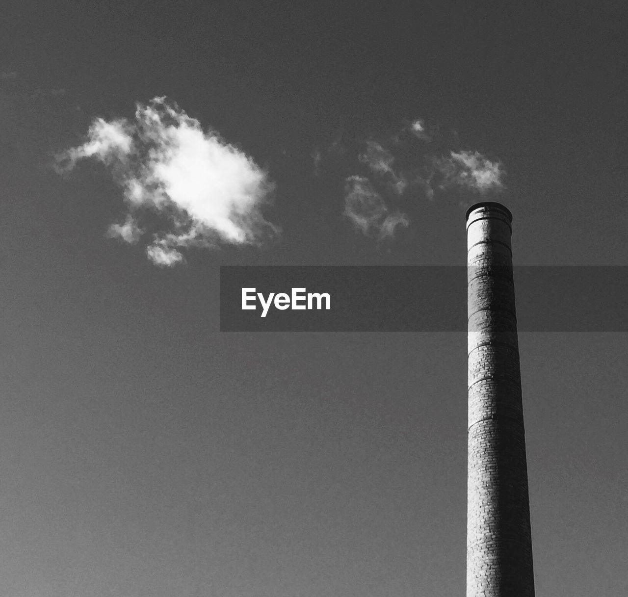 Low angle view of smoke emitting from chimney against sky