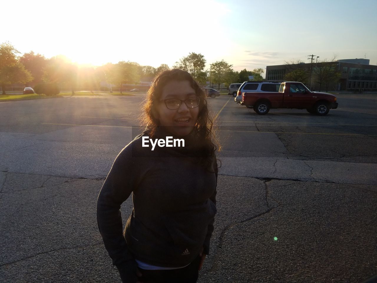 WOMAN STANDING ON ROAD DURING SUNSET