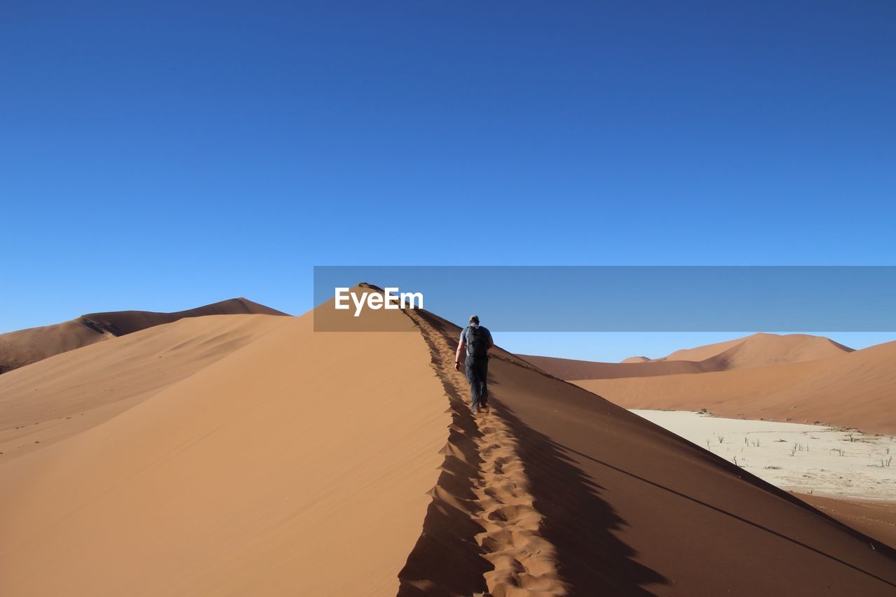 Scenic view of desert against clear blue sky