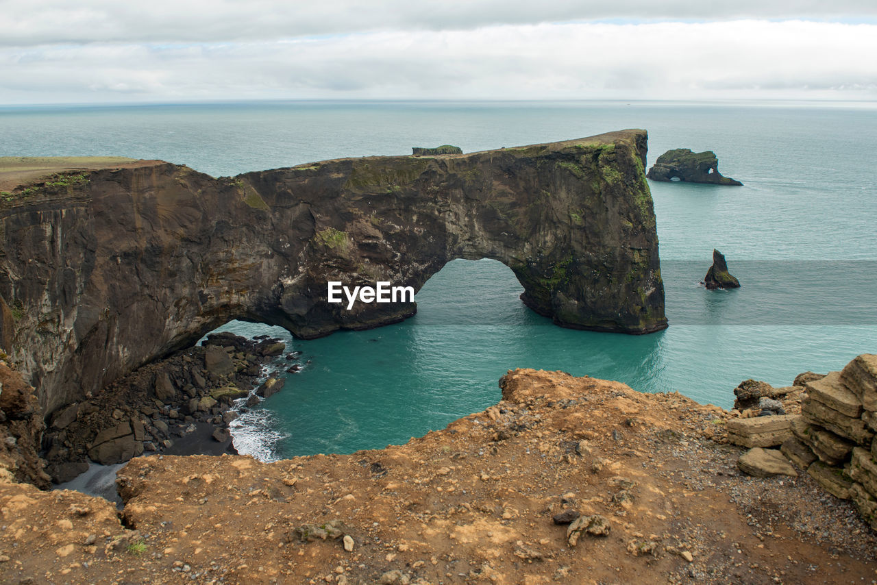 Rock formations by sea against sky