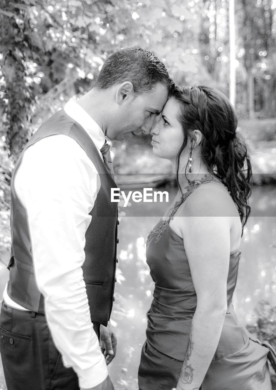 Close-up of bride and groom with face to face standing outdoors