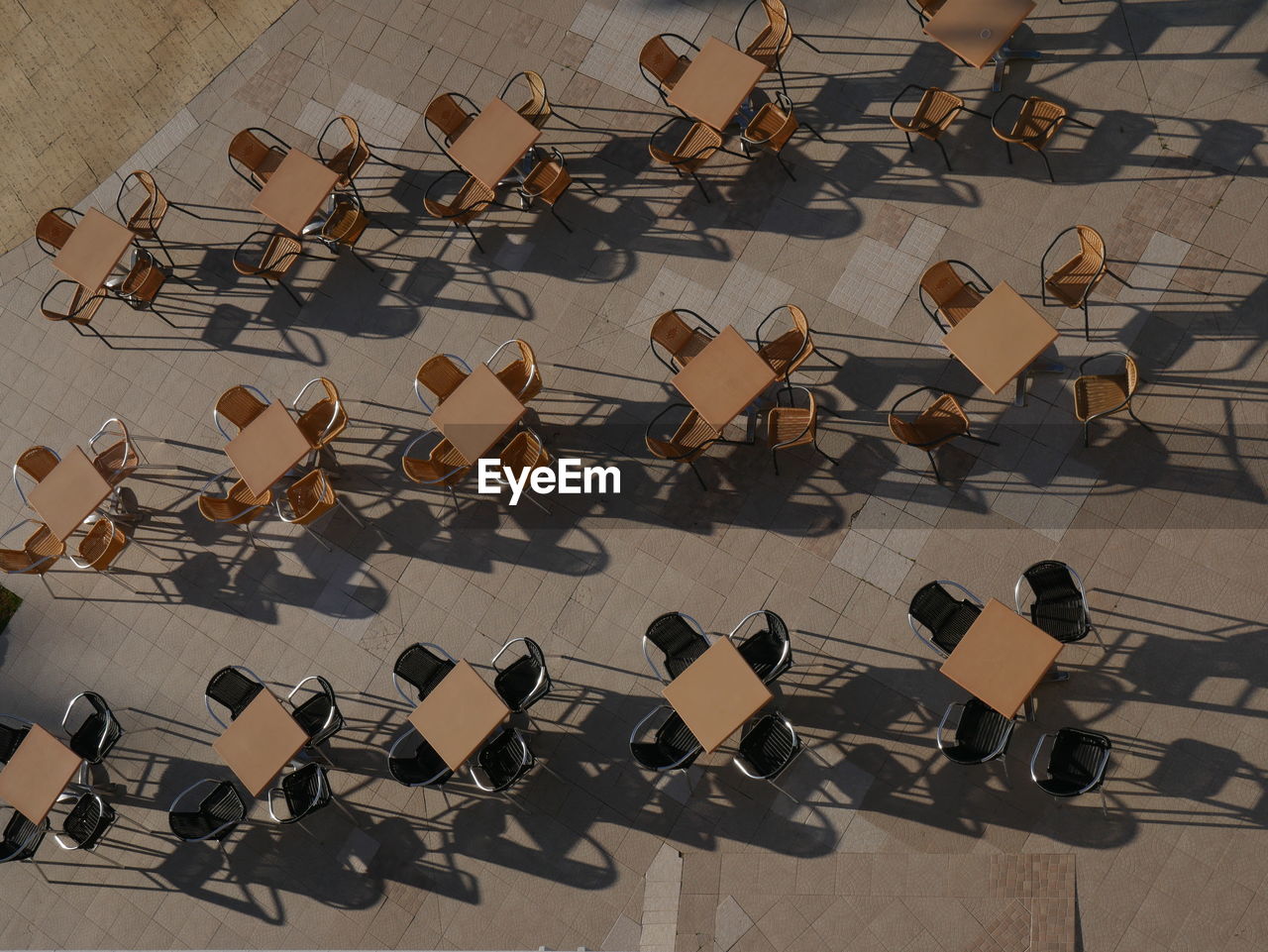 High angle view of chairs and tables arranged at sidewalk cafe