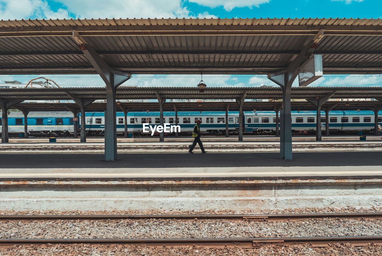 Side view of man walking on railroad station platform