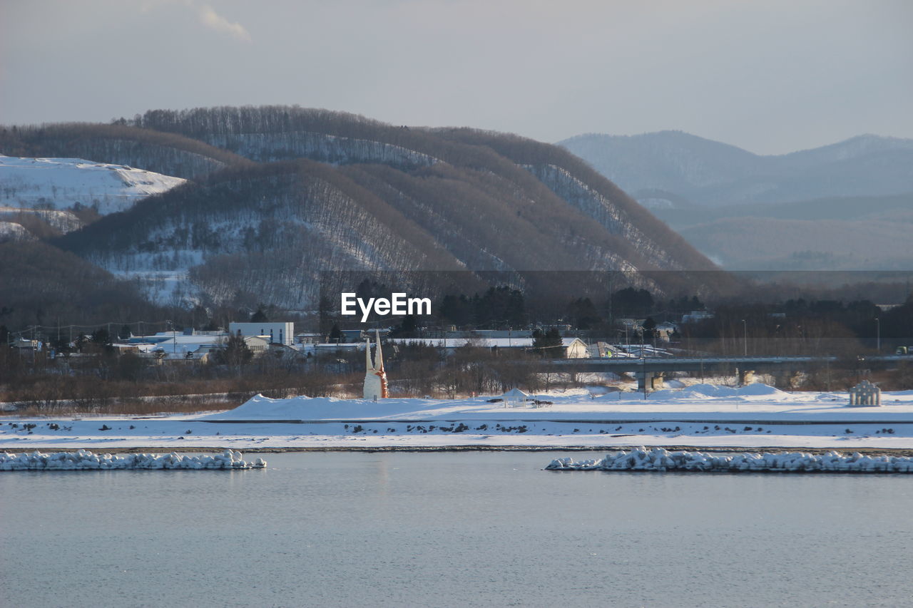 Scenic view of lake against sky during winter