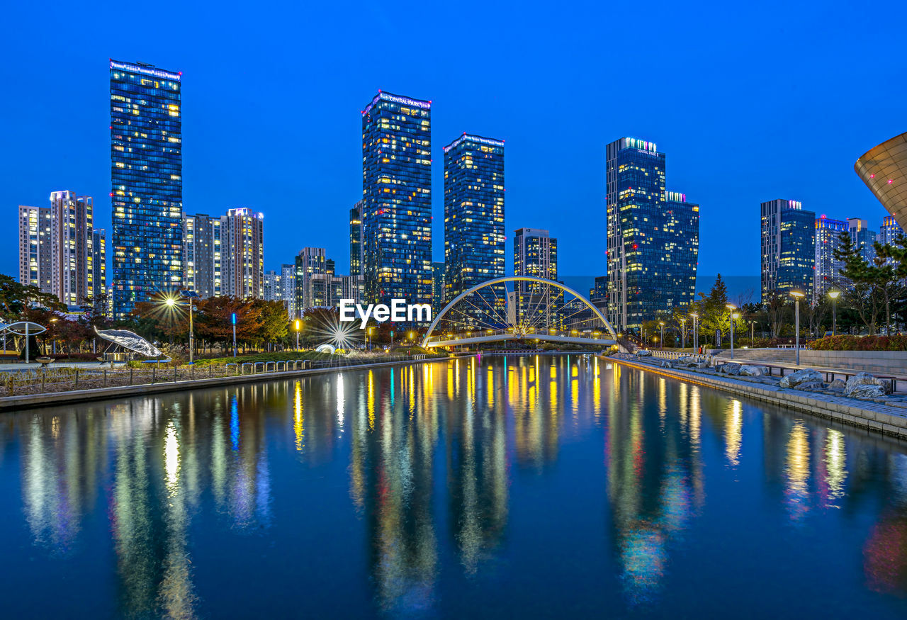 REFLECTION OF ILLUMINATED BUILDINGS IN BAY