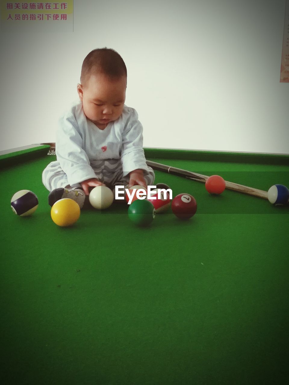 BOY PLAYING WITH BALL IN POOL