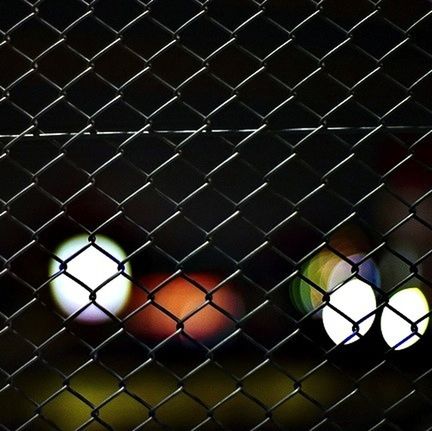 FULL FRAME SHOT OF CHAINLINK FENCE AT NIGHT