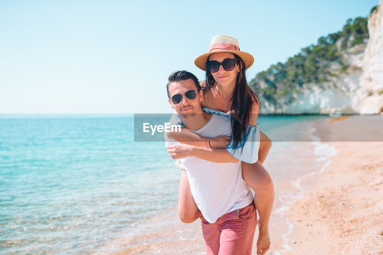 Portrait of couple piggybacking on beach