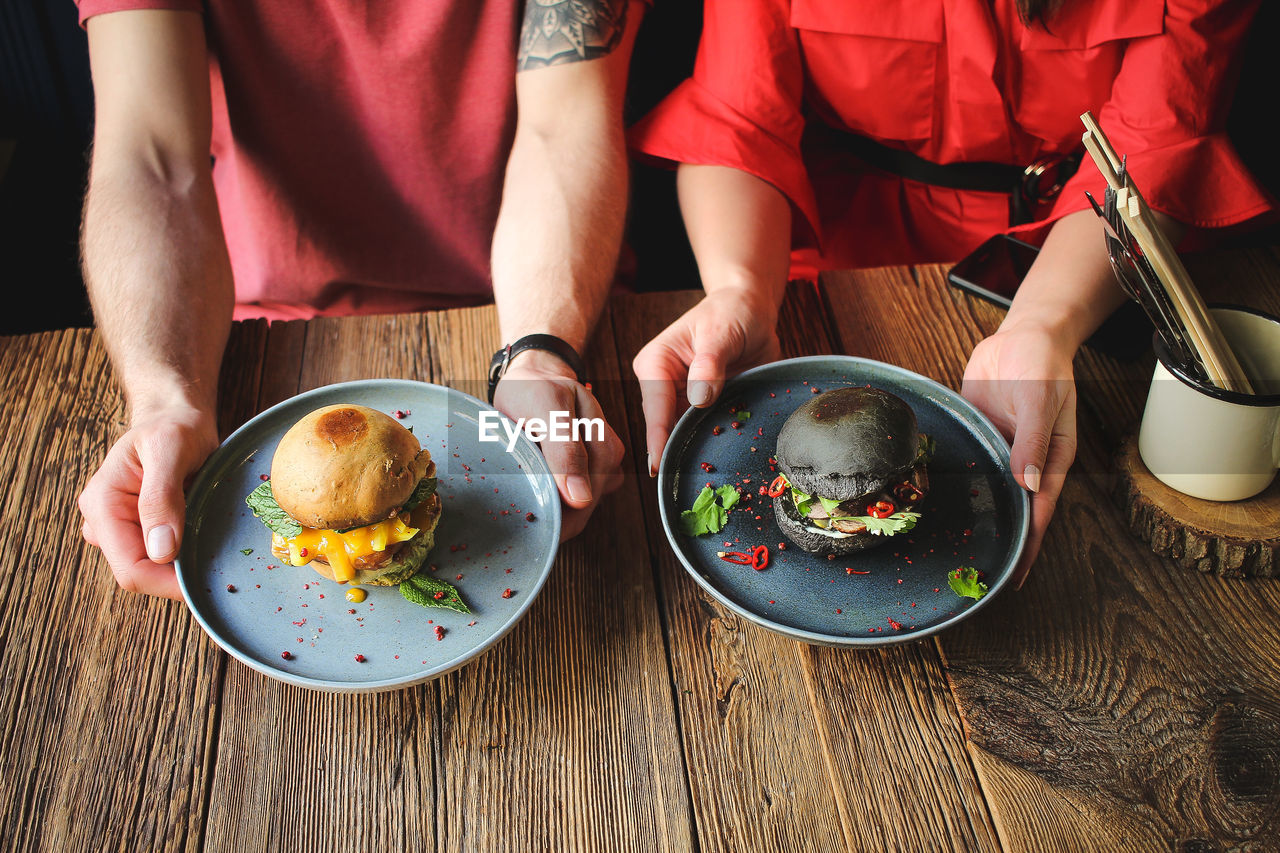 HIGH ANGLE VIEW OF PEOPLE HAVING FOOD IN KITCHEN