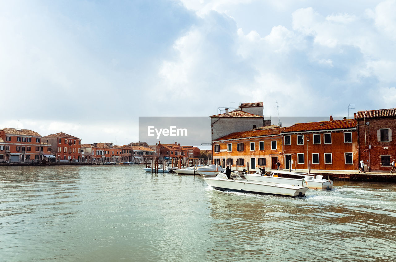 View of sailboat in venice against cloudy sky