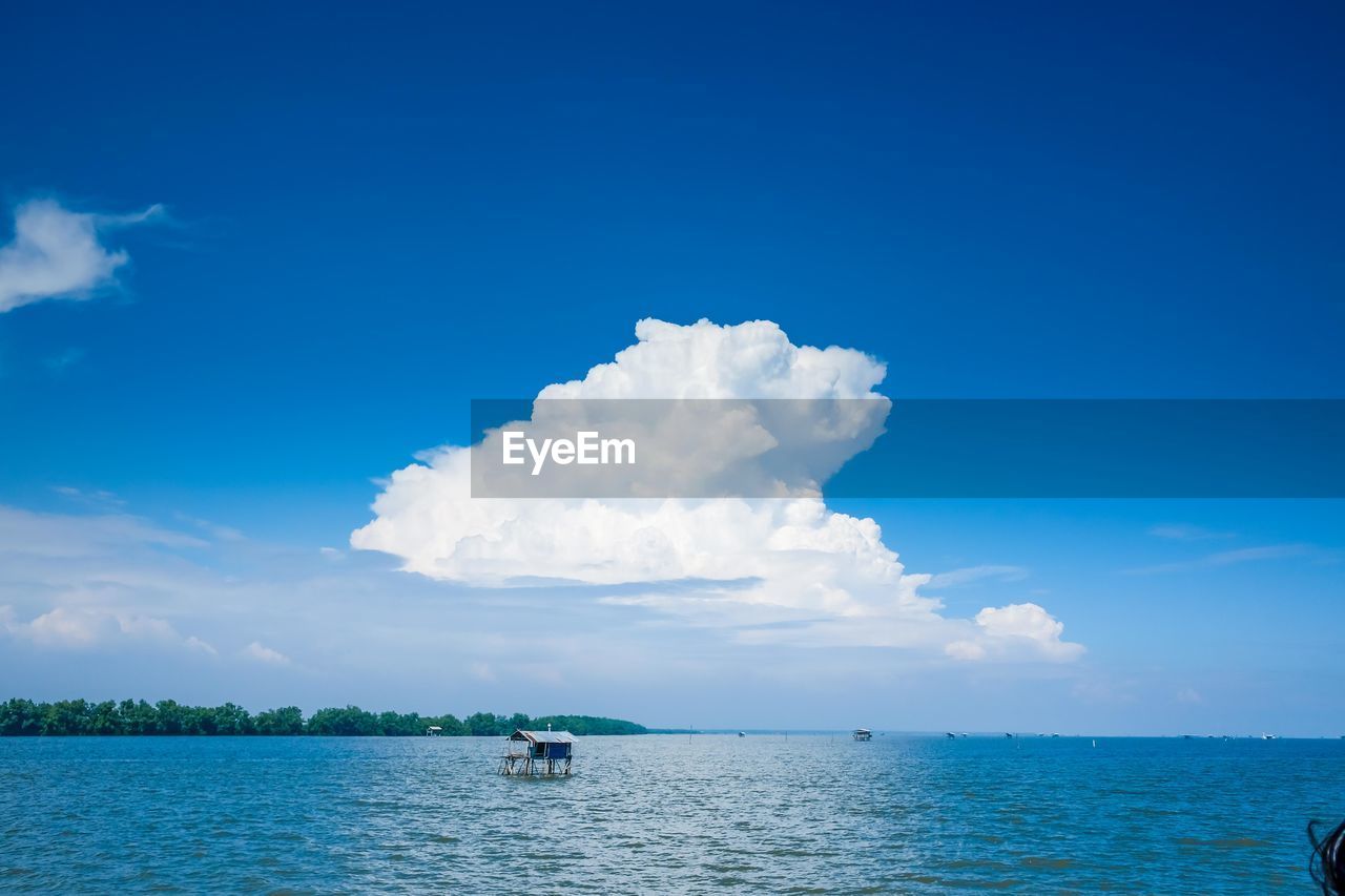 Scenic view of built structures in sea against blue sky