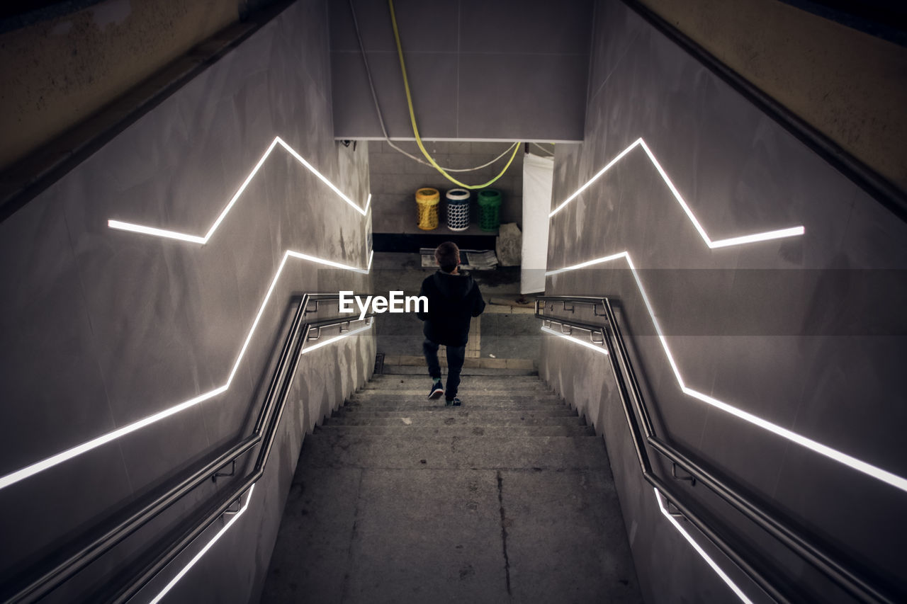 Rear view of man walking in subway