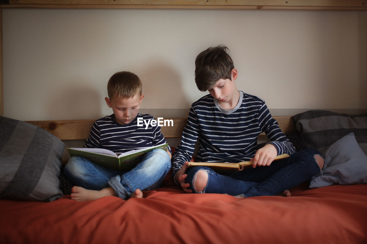 The brothers read together on two bunk beds in the nursery, the concept of kinship and childhood, 