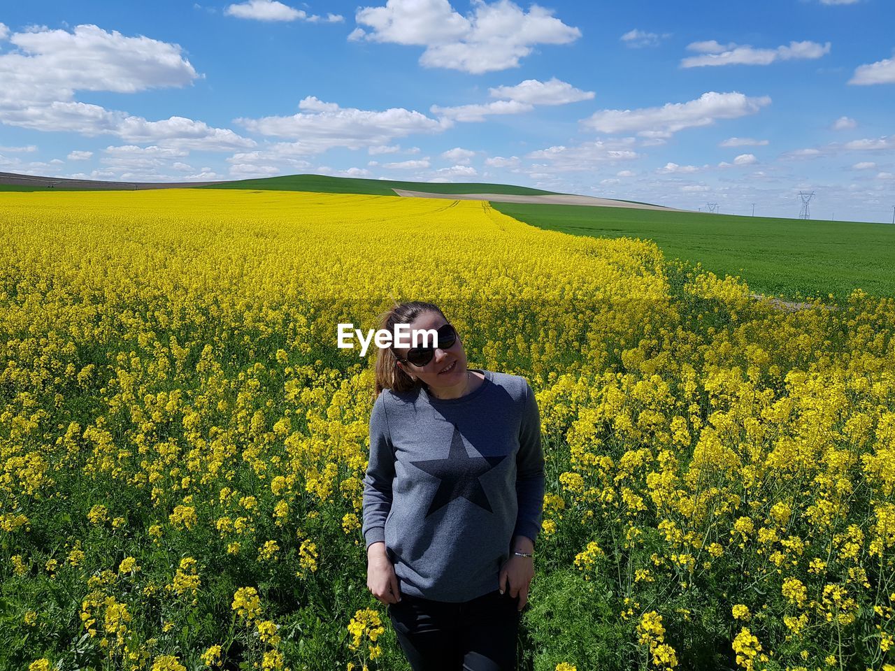 Woman standing amidst oilseed rape